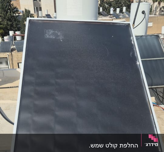 קולטן שמש ומיכל מים על גג בניין